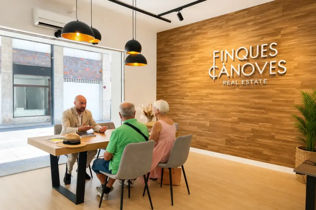 Asesor inmobiliario de Finques Cànoves atendiendo a una pareja durante una reunión para la compra o venta de una vivienda en Girona.